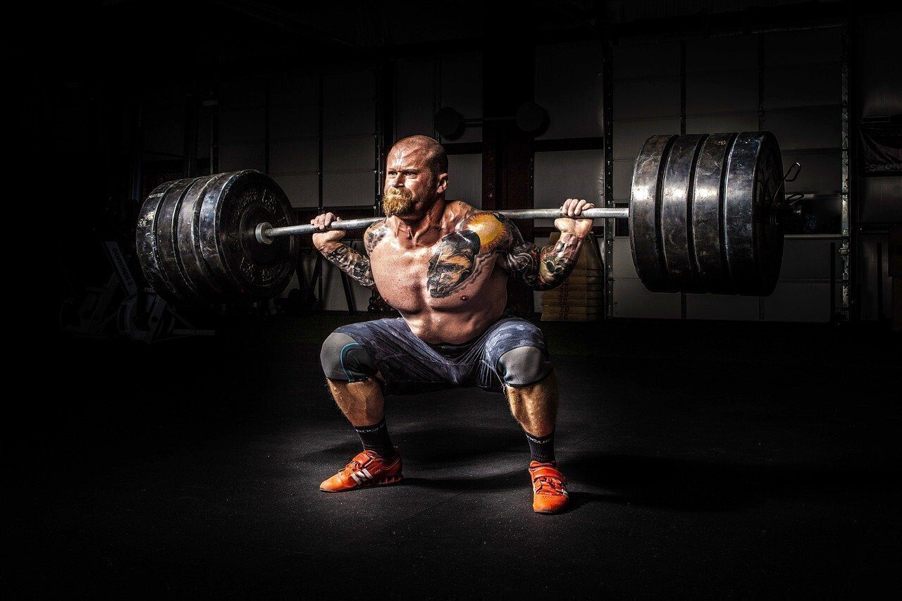 Hombre hace pesas en el gimnasio.